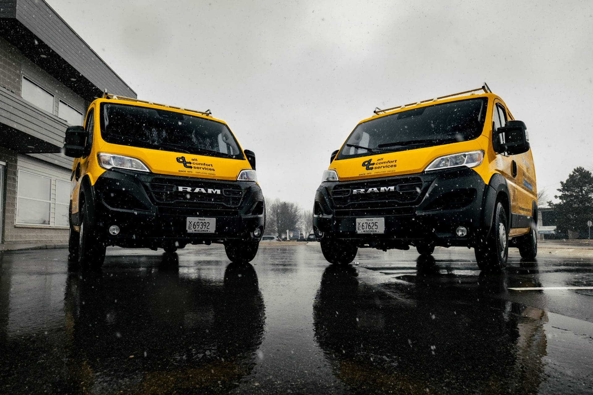 Two ram commercial vans with yellow vehicle wrap promoting local business